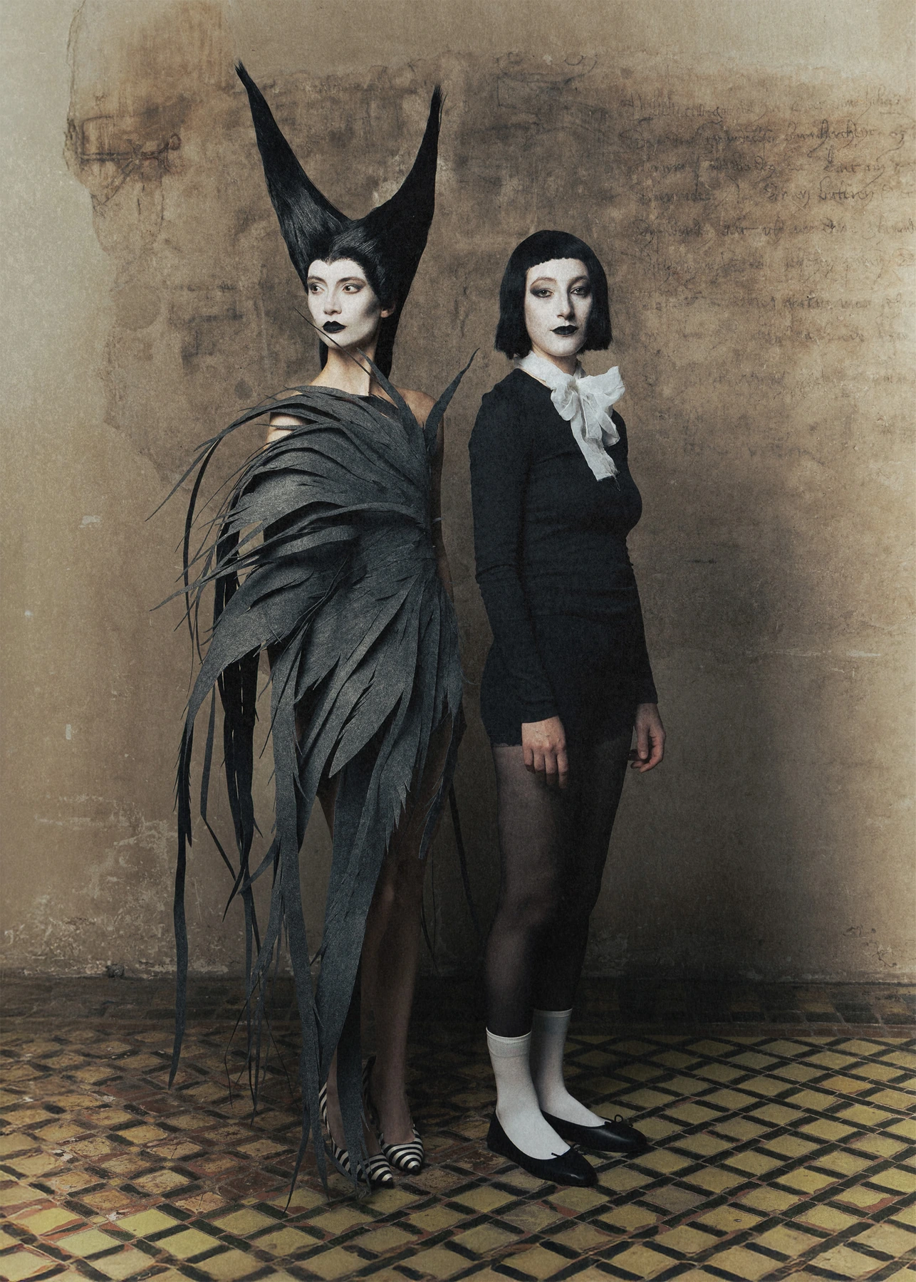 Two Hellion silhouettes photographed against a textured wall.