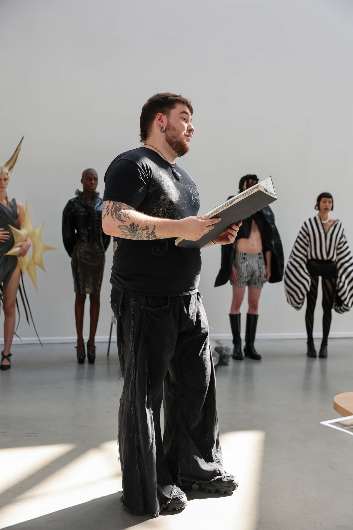 Storm Nijhuis speaking about his collection, with models wearing Hellion behind him.