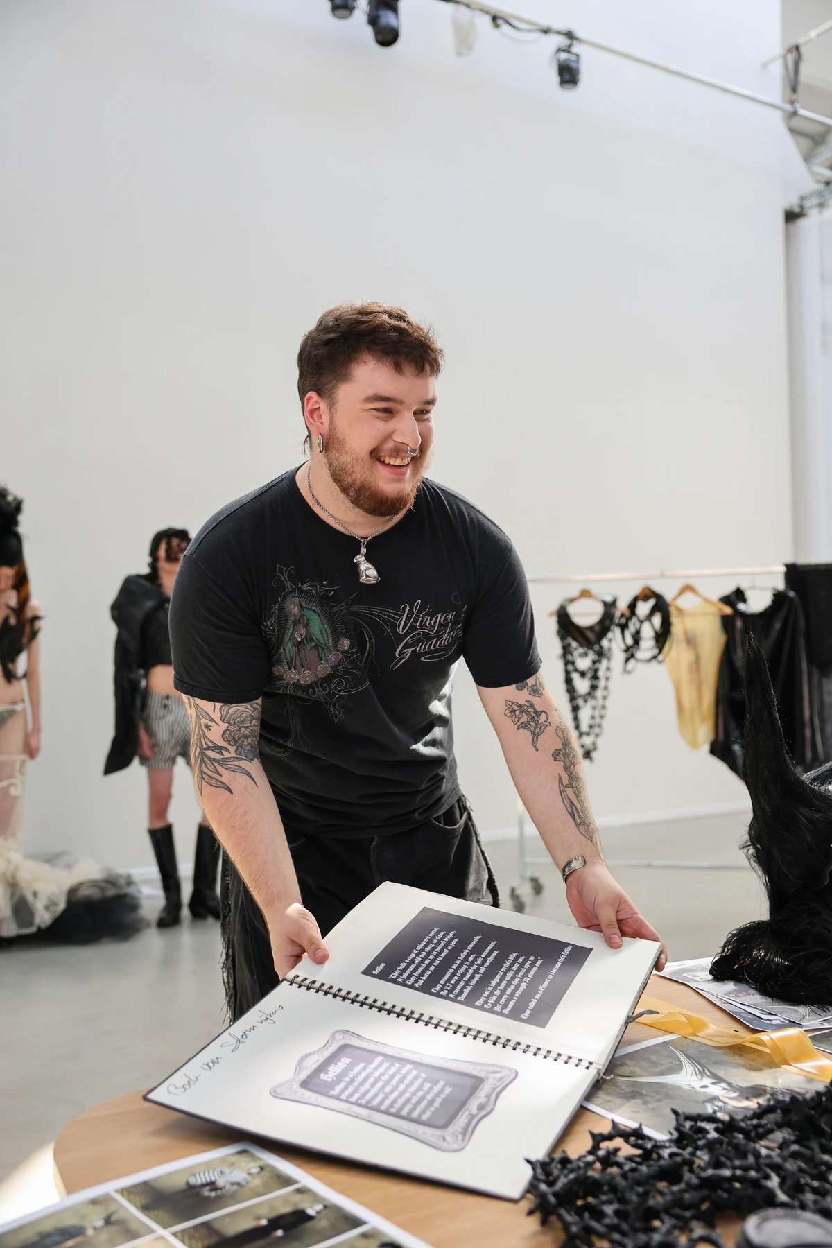 Storm Nijhuis presenting his collection book alongside the Hellion garments and models.